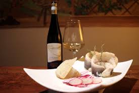 Fles Lugana DOC van Turbiana op houten tafel met visgerecht